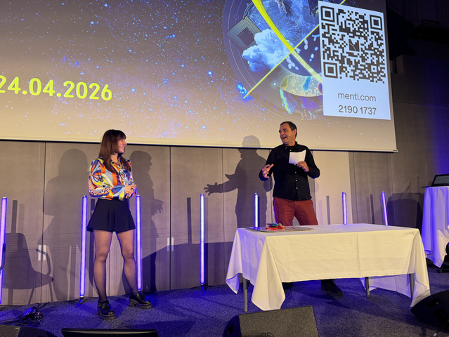Caroline Koenig and the moderator Bernhard Weingartner standing on a stage.